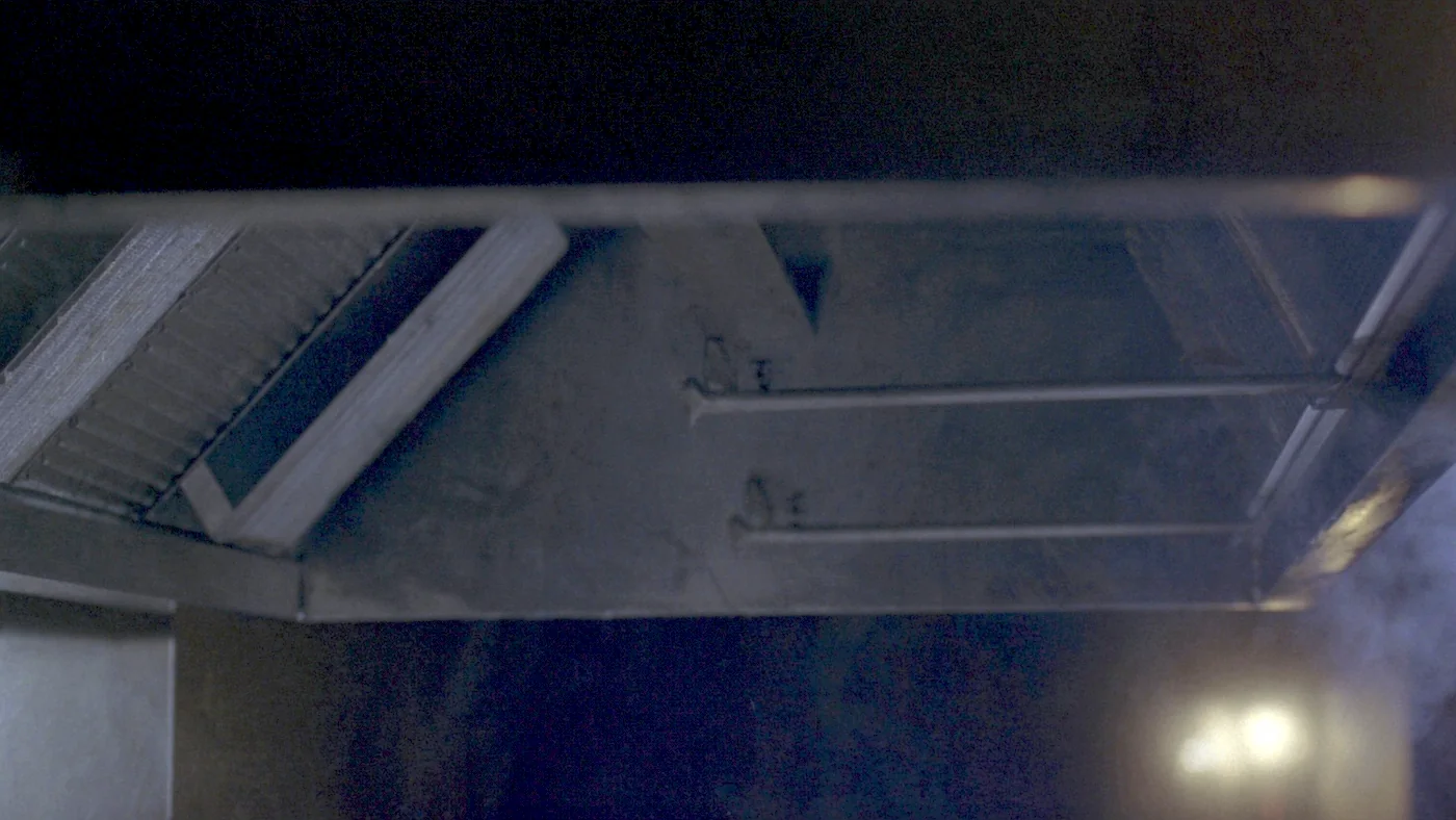 A commercial kitchen extract canopy running late at night after service